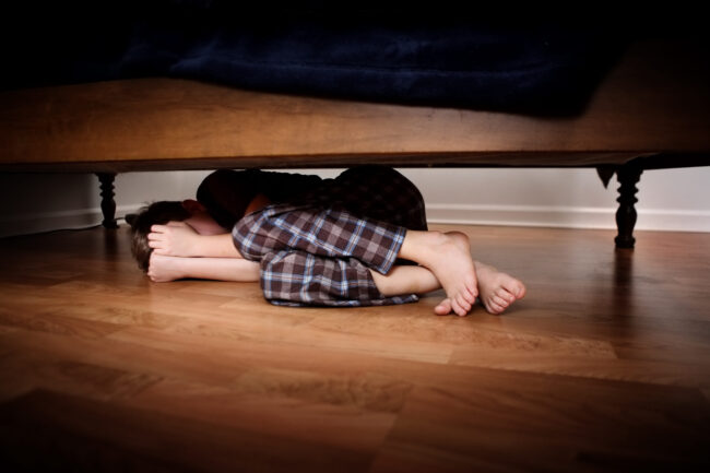 Fearful,Boy,Hiding,Under,The,Bed