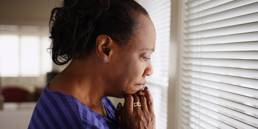 An,Older,Black,Woman,Mournfully,Looks,Out,Her,Window