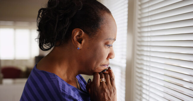 An,Older,Black,Woman,Mournfully,Looks,Out,Her,Window