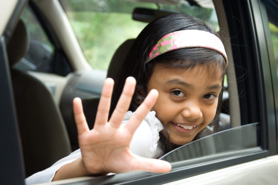 Little,Girl,Waving,Goodbye,From,Inside,Of,A,Car