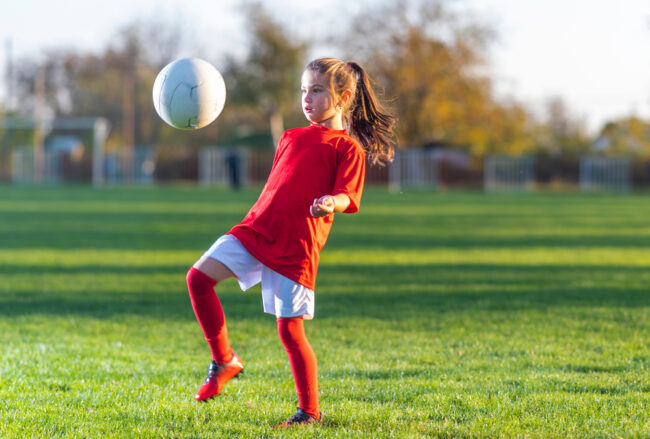 Girl,Kicks,A,Soccer,Ball,On,A,Soccer,Field