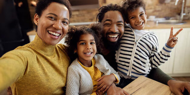 alegre-familia-negra-se-divertindo-enquanto-tira-selfie-em-casa_637285-13012